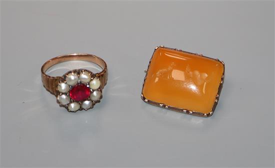 A Victorian yellow metal and carnelian? set brooch, carved with a seated dog and winged heart and a yellow metal ring.